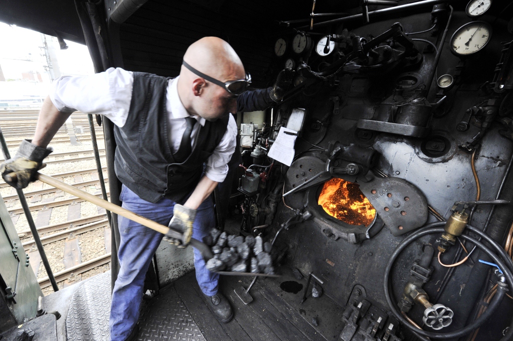 Um mecânico coloca carvão na caldeira de uma locomotiva (Georges Gobet/AFP/Getty Images) 