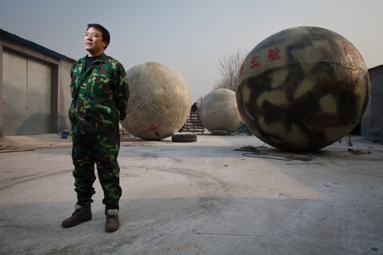 Liu Qiyuan posa diante de suas cápsulas de sobrevivência (Ed Jones/AFP/Getty Images)