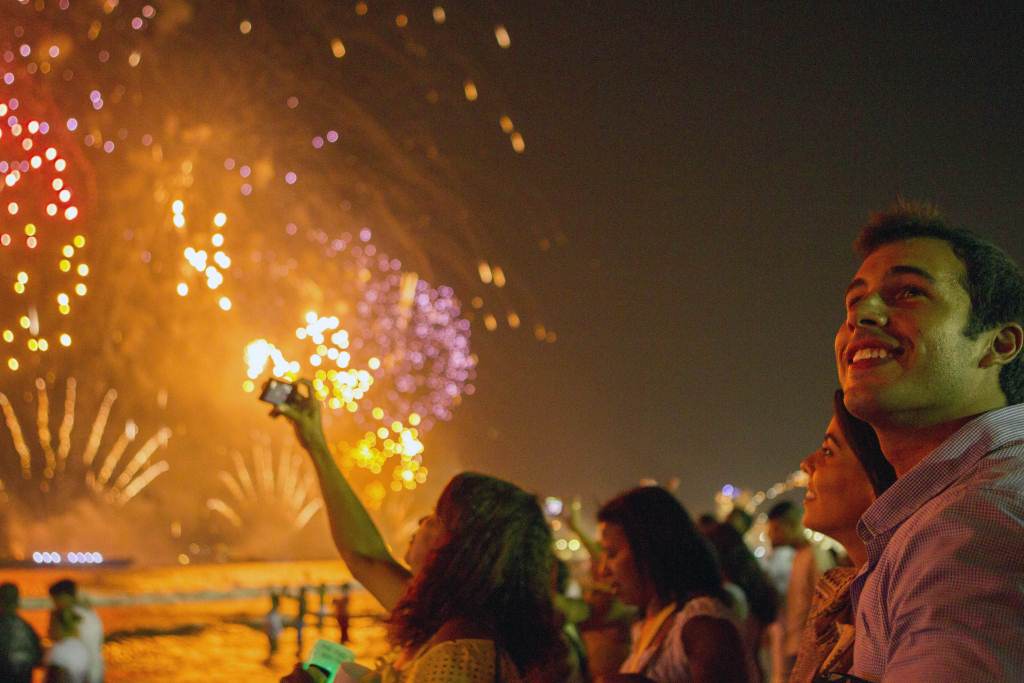 Pessoas olham admiradas os fogos de artifício na Praia de Copacabana, no Rio de Janeiro,  1º de janeiro de 2013 (Ari Versiani / AFP / Getty Images)