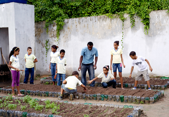 Crianças trabalham com horta comunitária como atividade de educação integral (Geyson Magno/Arquivo MEC)