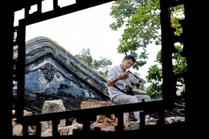 Um visitante lê um mapa num jardim tradicional em Suzhou. O sucesso econômico de Suzhou é meramente baseado na venda de terras e em vendê-las barato para fábricas que Shanghai não quer mais (Philippe Lopez/AFP/Getty Images)