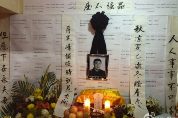 Poemas escritos por internautas para Xia Junfeng são colocados ao lado de sua imagem em sua casa. O funeral do vendedor de rua executado ocorreu em Shenyang em 1º de outubro (Weibo.com)