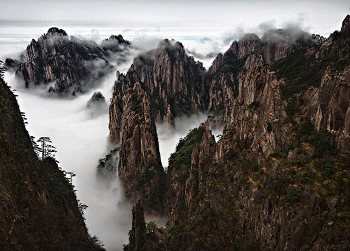 As montanhas Huangshan estÃ£o em meio a um mar nuvens.