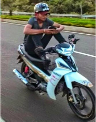 Motociclista tailandês envia torpedo enquanto dirige (Reprodução)