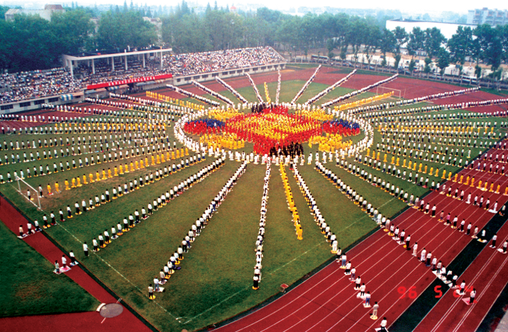 Praticantes do Falun Dafa da cidade de Wuhan, juntos, formando a imagem de uma Falun, 1996.