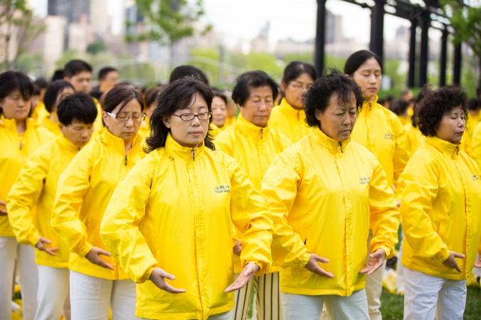 Praticantes do Falun Dafa realizando uma posição de um dos exercícios da prática.