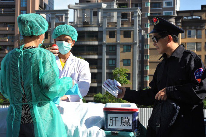 Praticantes de Falun Gong dramatizam uma remoção forçada de órgãos para serem vendidos, durante uma manifestação em Taipei no dia 20 de julho de 2014 (Mandy Cheng / AFP / Getty Images)
