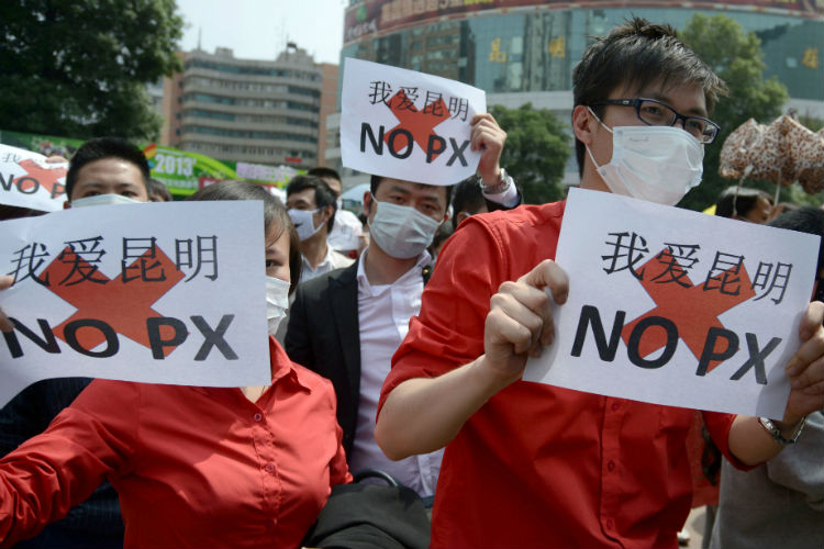 Manifestantes seguraram bandeiras durante uma manifestação contra os planos de construção de uma fábrica de paraxileno, também conhecido como PX, um petroquímico tóxico usado para fazer poliéster, em maio de 2013 (STR / AFP / Getty Images)