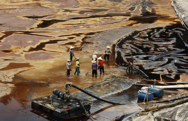 Trabalhadores drenam água contaminada perto da mina de cobre Zijin, em Shanghang, em 13 de julho de 2010, depois que os resídios da mina contaminaram o rio Ting, uma das principais vias navegáveis na província sudeste chinesa de Fujian (STR/AFP/Getty Images)