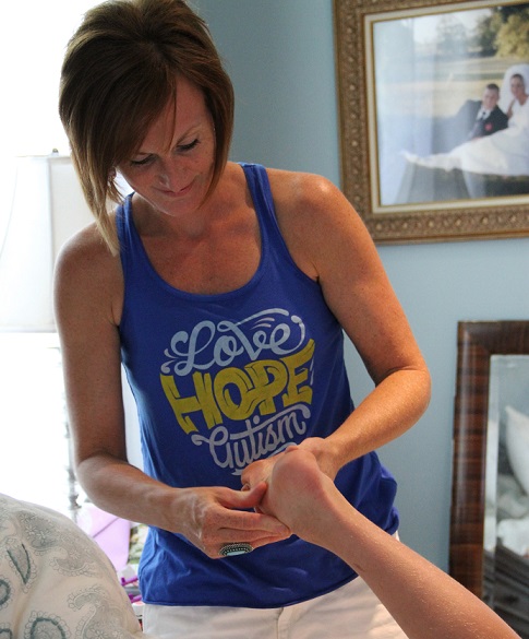 Shannon Coconis, aplicando óleos essenciais nos pés de seu filho com autismo (Cortesia do Wexner Medical Center, de OSU)