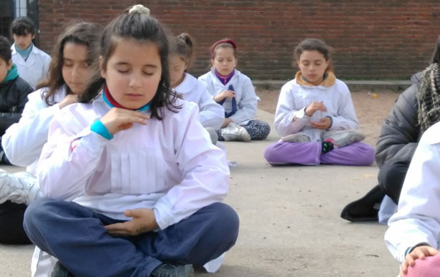 Alunos em escola de Montevidéu, Uruguai, praticando meditação, o quinto e último exercício do Falun Dafa (Reprodução)