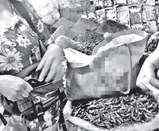 Uma mulher em Pequim vendendo sementes de papoula. Dois restaurantes do Sul da China foram descobertos servindo comida com semente de papoula em pó, que contém substâncias que causam dependência, como codeína e morfina (Imagem da internet)