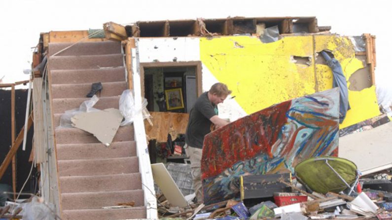 Homem anda entre os escombros de sua casa na cidade de Washington, Illinois, após passagem de tornando (The Pantagraph/Steve Smedley)