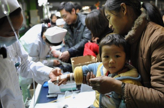 Grupo de crianças chinesas, acompanhados pelos seus pais, recebem tratamento para a gripe em um hospital em Hefei, província de Anhui, leste da China, em 8 de janeiro de 2010 (STR / AFP / Getty Images)