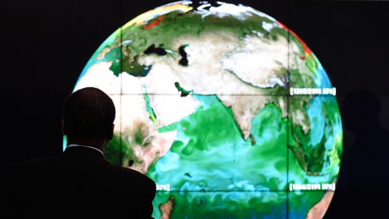 Um participante da conferência olha para uma projeção da Terra no primeiro dia da conferência COP 21 da ONU sobre mudança climática em Le Bourget, França, em 30 de novembro de 2015. (Alain Jocard/AFP/Getty Imagens)