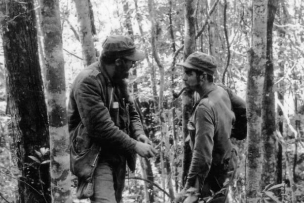 Foto de 8 de outubro de 1957 mostra o líder cubano Fidel Castro (esq.) conversando com Ernesto “Che” Guevara (dir.) em meio à floresta da Sierra Maestra, em Cuba (Arquivo/AFP/Getty Images)