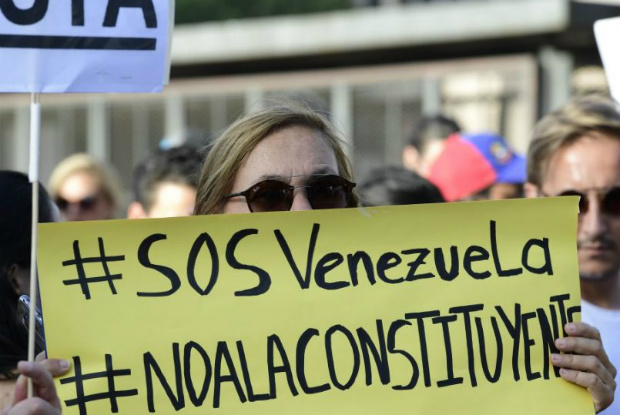 Venezuelana segura cartaz durante protesto em 30 de julho de 2017 contra o ditador venezuelano Nicolás Maduro e a eleição de uma Assembleia Constituinte (Javier Soriano/AFP/Getty Images)