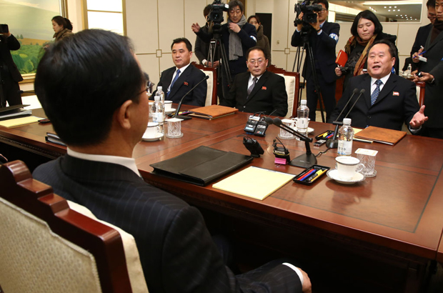 Ri Son-gwon (dir.), o chefe da delegação norte-coreana, fala com Cho Myung-gyun (costas dir.), o ministro da unificação sul-coreano, durante um encontro na vila fronteiriça de Panmunjom, na Zona Desmilitarizada (DMZ) que divide as duas Coreias, em 9 de janeiro de 2018 (AFP/Getty Images)