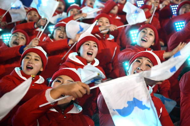 Membras da equipe de torcedoras da Coreia do Norte agitam bandeiras nacionais antes da cerimônia de abertura dos Jogos Olímpicos de Inverno de 2018 no Estádio Pyeongchang, na Coreia do Sul, em 9 de fevereiro de 2018 (Franck Fife/AFP/Getty Images)