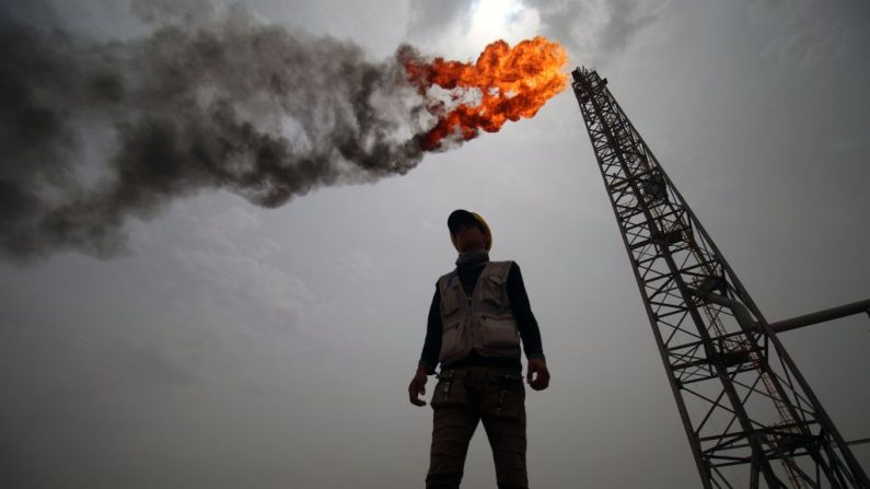 Um funcionário diante das novas instalações da estação de desgaseificação de Hammar Mushrif, no campo de petróleo e gás de Zubair, ao norte da província de Basra, no sul do Iraque, em 9 de maio de 2018 (Haidar Mohammad Ali/AFP/Getty Images)