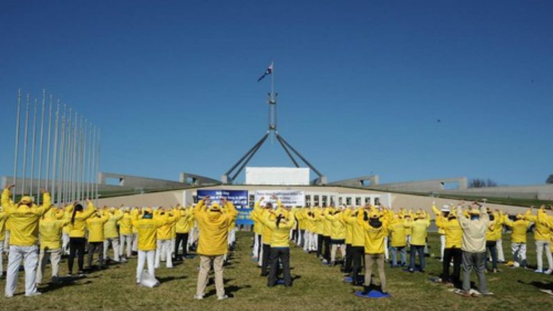Praticantes do Falun Gong fazem os exercícios juntos em frente ao Parlamento Australiano (Minghui)
