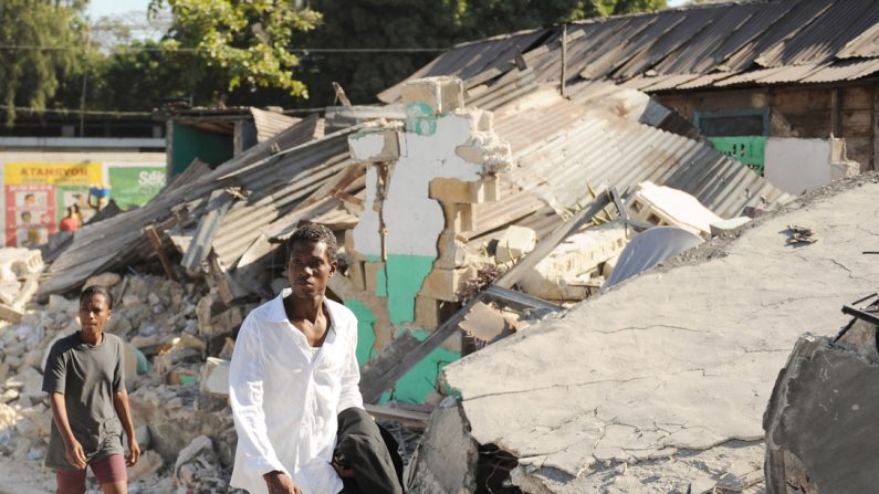 Haitianos passam por destroços em 17 de janeiro de 2010, em Porto Príncipe, Haiti, após um terremoto de magnitude 7 que atingiu a cidade em 12 de janeiro de 2010. Os ativos do Departamento de Defesa foram enviados ao Haiti para assistência humanitária e desastre alívio (Foto da Força Aérea dos EUA / Sargento Técnico James L. Harper Jr.)