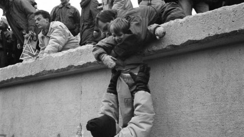 Berlinenses orientais escalam o Muro de Berlim para celebrar o fim efetivo da divisão da cidade, em 31 de dezembro de 1989 (Steve Eason/vHulton Archive/Getty Images)
