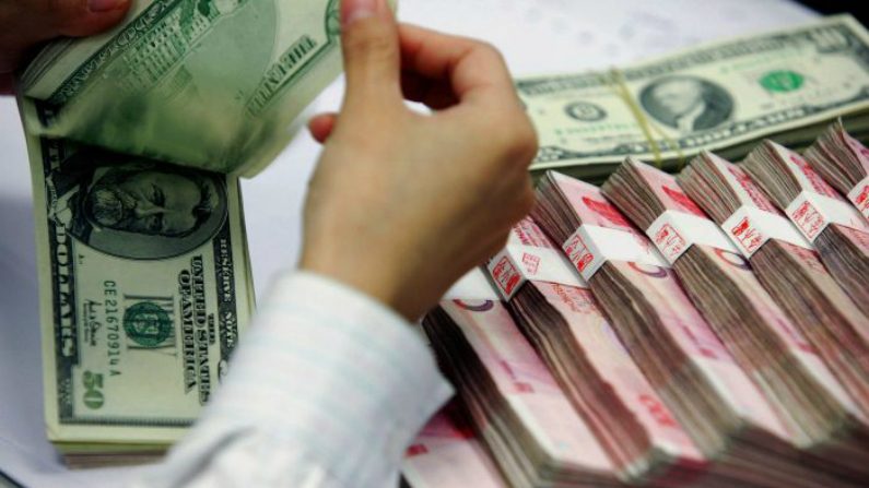 Bancário conta notas de dólares norte-americanos e iuanes chineses em um banco em Xangai, em 22 de julho de 2005 (STR/AFP/Getty Images)