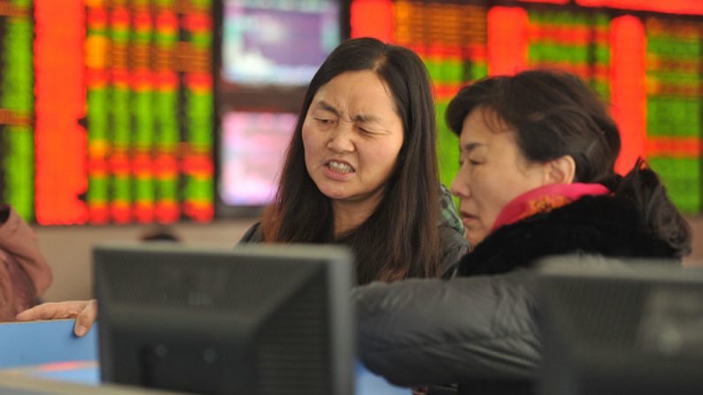 Investidores observam oscilação das ações na bolsa de valores em 4 de janeiro de 2016 em Fuyang, província de Anhui, China (ChinaFotoPress via Getty Images)