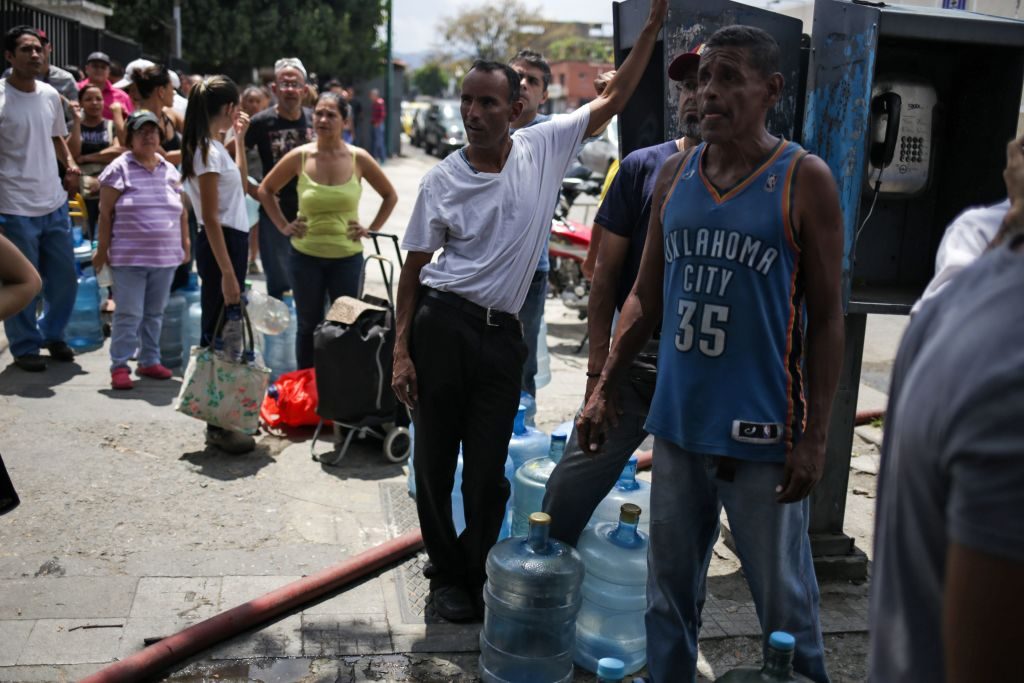 Pessoas fazem fila para conseguir água potável em Caracas em 10 de março de 2019, durante o terceiro dia de um apagão em massa que deixou os venezuelanos sem comunicações, eletricidade e água (CRISTIAN HERNANDEZ / AFP / Getty Images)