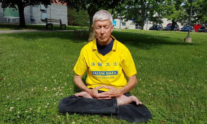 O praticante do Falun Gong Gerry Smith, visto aqui meditando em um parque, foi ordenado pelo CEO do Festival do Barco-Dragão de Ottawa para remover sua camiseta com o nome de sua prática espiritual em 22 de junho de 2019, no festival. John Brooman disse a Smith que a embaixada chinesa é patrocinadora do festival e não queria adeptos do Falun Gong no evento (The Epoch Times).