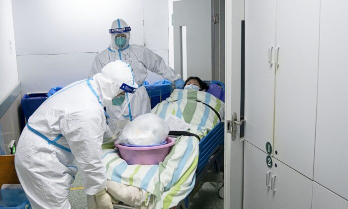 Equipe médica transfere um paciente para fora da unidade de terapia intensiva no Hospital Zhongnan da Universidade Wuhan, em Wuhan, na província central de Hubei, na China. em 24 de janeiro de 2020 (Zong Qi / Xinhua via AP)