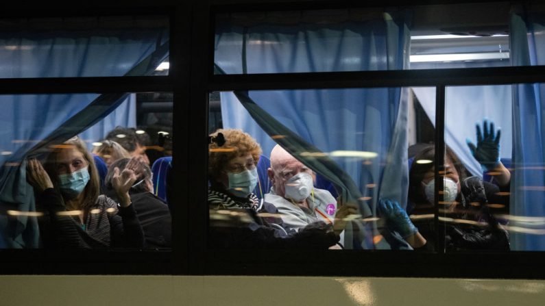 Cidadãos norte-americanos cumprimentam um ônibus enquanto deixam o navio Diamond Princess em quarentena no cais de Daikoku para serem repatriados para os Estados Unidos em 17 de fevereiro de 2020, em Yokohama, Japão (Carl Court / Getty Images)