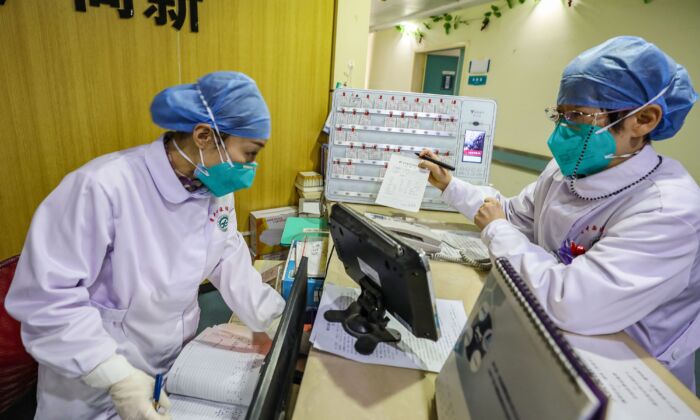 Membros da equipe médica usando máscaras e conversando em um hospital em Wuhan, China, em 30 de janeiro de 2020 (STR / AFP via Getty Images)