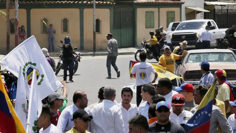 Fotografia cortesia da assessoria de imprensa de Juan Guaidó revela o líder da oposição Juan Guaidó (centro, direita) em um ato com seus seguidores, enquanto encapuzados em motocicletas (atrás, esquerda) os afastam da área, em Barquisimeto, Venezuela (Assessoria de Imprensa EFE / Juan Guaidó)