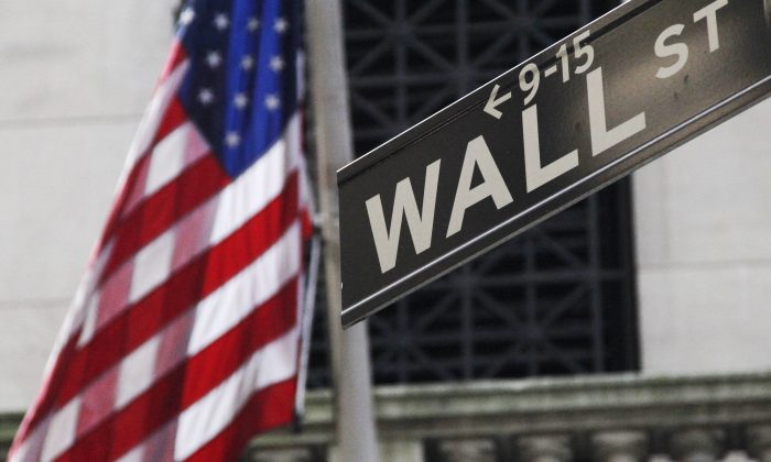 A bandeira americana e a rua Wall Street assinam fora da Bolsa de Valores de Nova York, em Nova York, em 27 de junho de 2014. (Mark Lennihan / AP Photo)