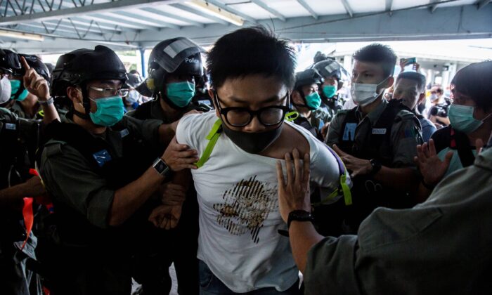 Policiais prendem um manifestante pró-democracia (centro) durante um protesto pró-democracia pedindo a independência da cidade em Hong Kong, em 10 de maio de 2020 (Isaac Lawrence / AFP via Getty Images)