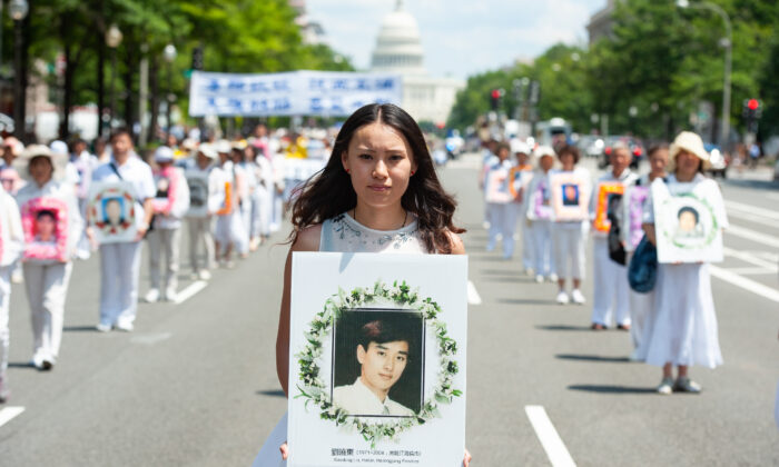 Uma mulher segura uma foto de um homem morto na perseguição do regime chinês ao Falun Gong, durante um desfile em Washington em 17 de julho de 2014 (Larry Dye / The Epoch Times)