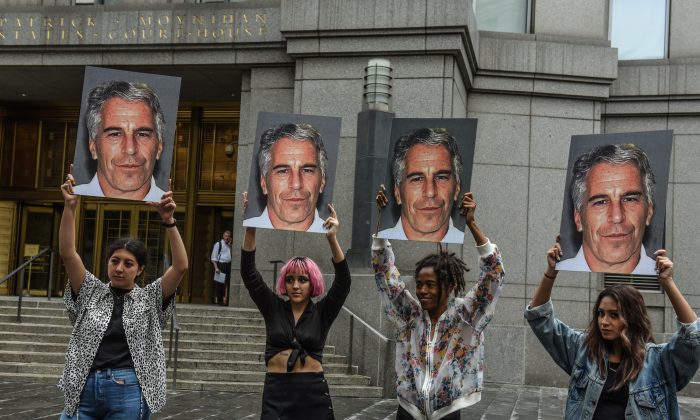 Um grupo de protesto chamado "Hot Mess" exibe pôsteres de Jeffrey Epstein do lado de fora do tribunal na cidade de Nova Iorque em 8 de julho de 2019 (Stephanie Keith / Getty Images)