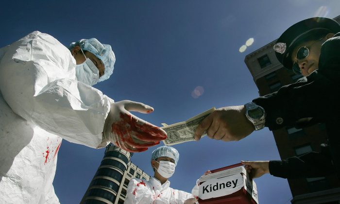Ativistas chineses dramatizam um ato ilegal de pagamento por órgãos humanos durante um protesto em 19 de abril de 2006 em Washington, D.C. (Jim Watson / AFP via Getty Images)