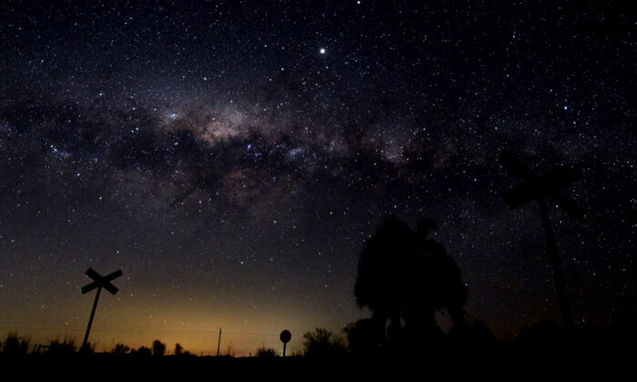 A Via Láctea, seu centro galáctico, e Júpiter (o ponto mais brilhante no topo do centro) são vistos do interior perto da pequena cidade de Reboledo, departamento da Flórida, Uruguai (MARIANA SUAREZ / AFP via Getty Images)