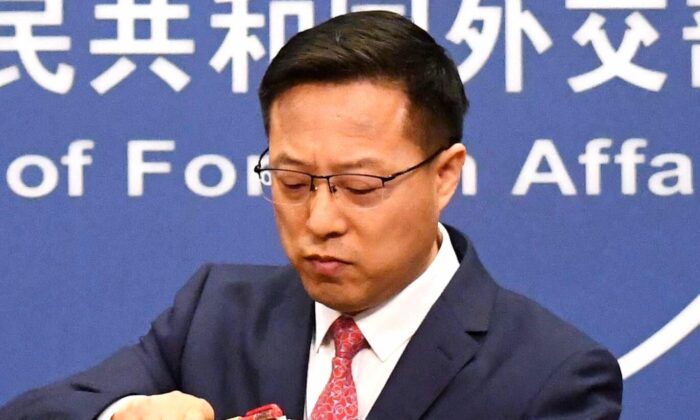 O porta-voz do Ministério das Relações Exteriores da China, Zhao Lijian, faz as malas após falar na coletiva de imprensa diária em Pequim em 8 de abril de 2020 (Greg Baker / AFP via Getty Images)
