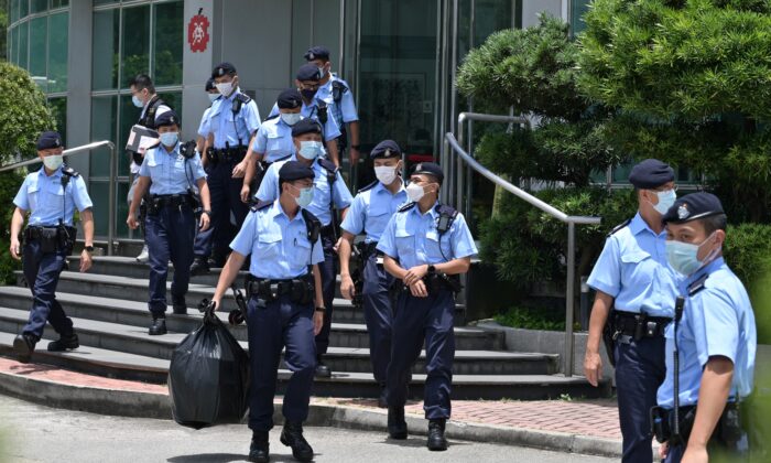 Policiais deixam os escritórios do jornal Apple Daily em Hong Kong após uma batida de mais de 500 policiais em 17 de junho de 2021 (Anthony Wallace / AFP via Getty Images)
 