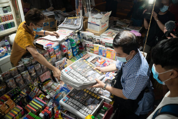 Um homem compra várias cópias da última edição do Apple Daily em Hong Kong em 18 de junho de 2021 (Anthony Kwan / Getty Images)
