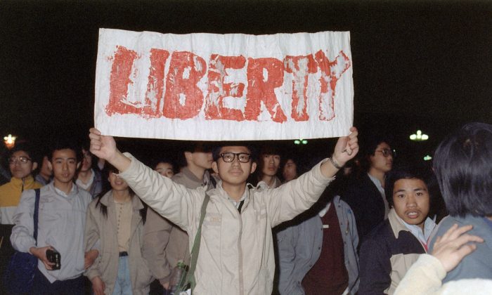 Um estudante segura uma faixa com um dos slogans entoados pela multidão de cerca de 200.000 que se aglomeraram na Praça Tiananmen em Pequim em 22 de abril de 1989 (Catherine Henriette / AFP / Getty Images)

