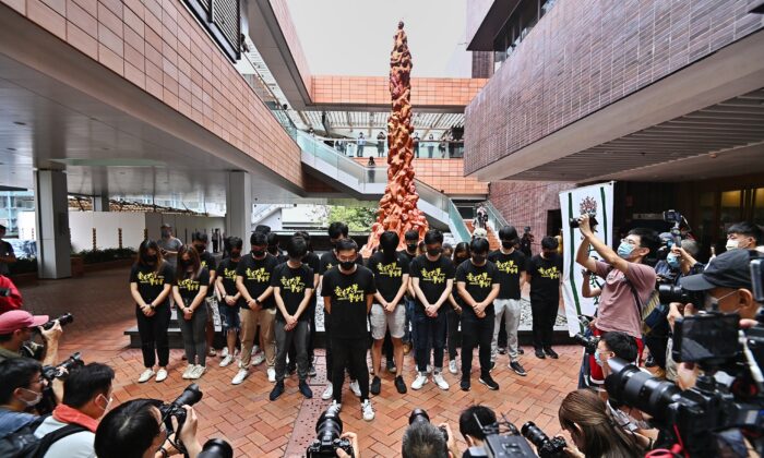Membros da União de Estudantes da Universidade de Hong Kong observam um momento de silêncio diante do Pilar da Vergonha em Hong Kong em 4 de junho de 2021 (Sung Pi-lung / The Epoch Times)
 