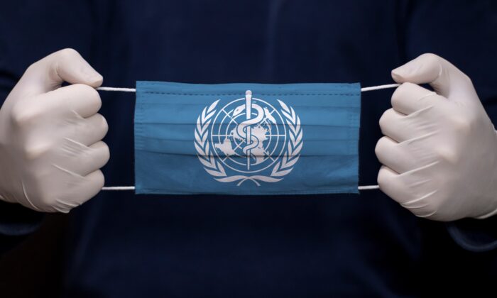 Um médico segura uma máscara médica com a bandeira da Organização Mundial da Saúde (OMS)(kcube-Baytur / Shutterstock)
