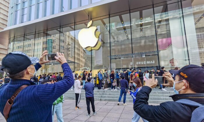 Os clientes fazem fila para obter seus telefones celulares iPhone 12 reservados em uma loja da Apple em Xangai em 23 de outubro de 2020 (STR / AFP via Getty Images)