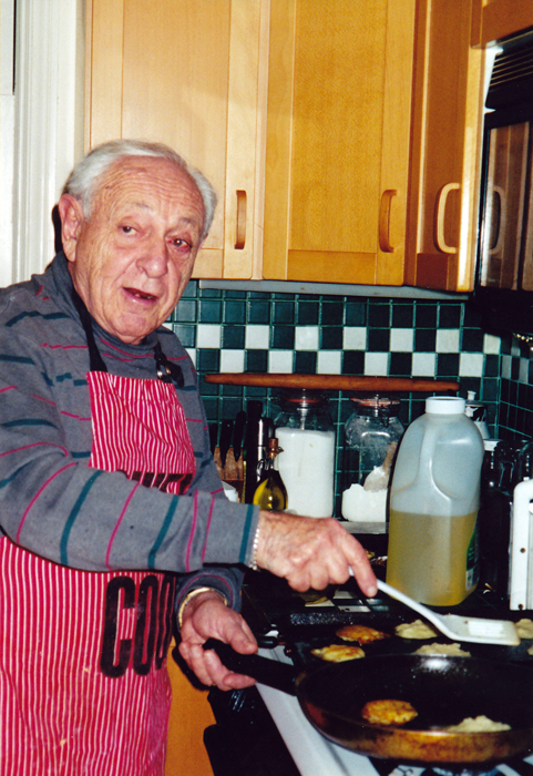 Falecido pai da autora fritando latkes em sua cozinha (Cortesia de Sandra Banas)