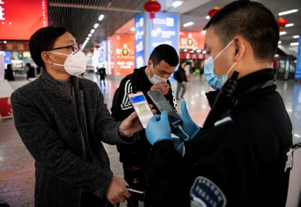 Um passageiro mostra um código QR verde em seu telefone para mostrar seu estado de saúde para a segurança ao chegar na Estação Ferroviária de Wenzhou, em Wenzhou, China, em 28 de fevereiro de 2020 (Noel Celis / AFP via Getty Images)